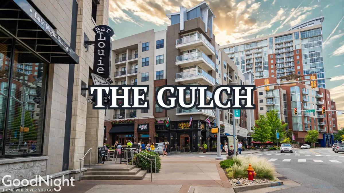 A vibrant city scene featuring Bar Louie and The Gulch sign, with modern apartment buildings in the background and people dining and socializing along the bustling street.